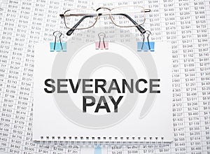 severance pay text written on paper with pen and glasses