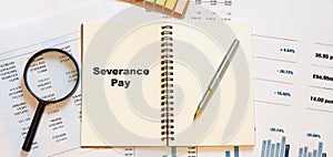 Severance Pay on white blank notepad with financial papers