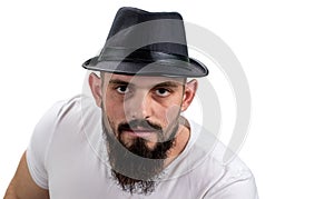 Severe bearded man in hat looking at camera isolated on white ba