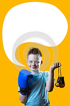 Severe boy in blue Boxing gloves on bright yellow background