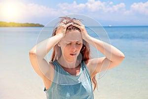 Severe headache on tropic seaside during vacation. Bright sun negative impact sunstroke
