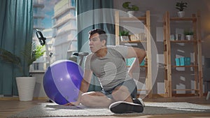 Severe pain in a man during a fitness class on a gym ball at home