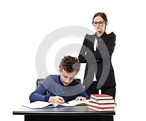 Severe teacher with arms folded standing behind the student's ba