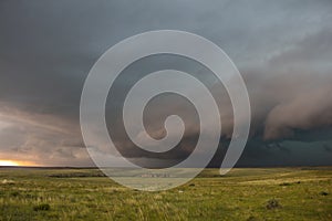 A severe thunderstorm approaches over the great plains landscape.