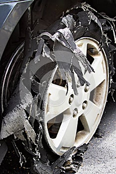 Severely Blown-out Tire with rubber ripped to shreds.