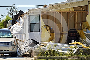 Severely damaged house and car after hurricane Ian in Florida mobile home residential area. Consequences of natural