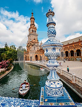 Juxtaposition of blue and white ceramic azulejo tiles against one of the baroque sandstone tower at Plaza de Espana in Seville, Sp