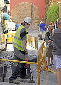 Builder worker with pneumatic hammer drill equipment