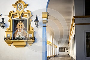 Seville: tabernacle with the Madonna del Baratillo, on the facade of a building. Spain.