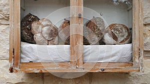 Sevral traditional bread in wooden show window of stone shop
