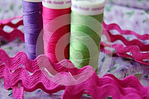 Sew Time! Three colorful spools of thread in purple, pink and green