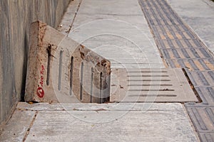 Sewage drain with open concret grate on the sidewalk, sewer.