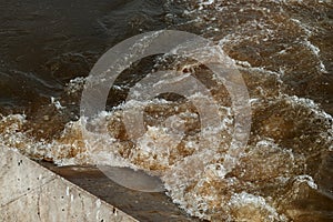 Sewage pipe outfall into the river, water pollution and environmental damage concept photo