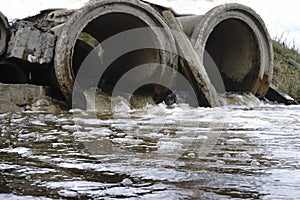 The sewage water flows through the old pipe