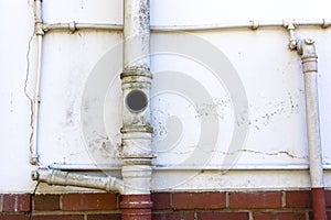 Sewage and Water Pipes on Wall of Residence
