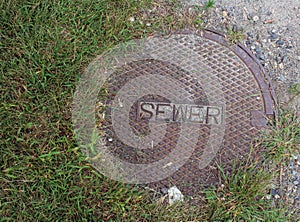 Sewer Cover with Grass and Gravel