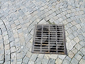 Sewer cover at paved stone