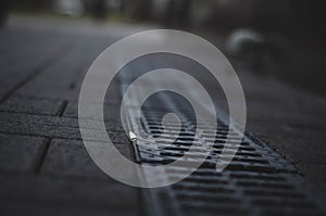 Sewer grate on the asphalt. in gray tones