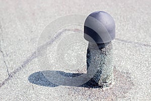 Sewer hood on the roof of a building against a gray roofing felt