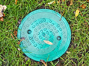 Sewer manhole in the autumn foliage