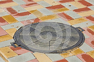 Sewer manhole cover surrounded by an street