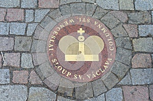 Sewer manhole with golden crown on cobblestone road