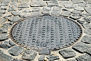 Sewer manhole on the stone pavement