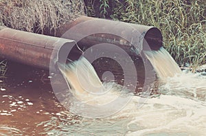 sewer pipes pour out to the river/sewer pipes pour out to the river. Toned