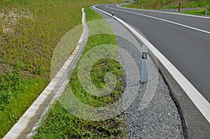 Sewer pipes under the bridge. crossing ditch by side road. concrete hole with stone paving surroundings. The gutter drains around