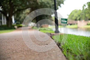 Sewer waste pipe line stake flag buried underground utility beside a footpath