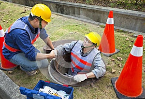 Sewerage workers in the manhole photo