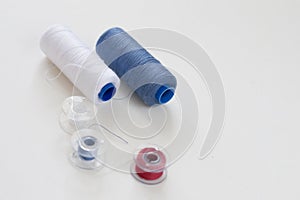 Sewing accessories on a light background close-up. Multi-colored spools of thread