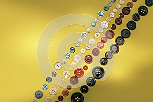 Sewing buttons of different sizes and colors arranged on a yellow background