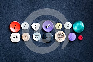 Sewing buttons lying on dark cloth
