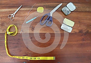 Sewing concept. Different sewing accessoires on a brown wooden background
