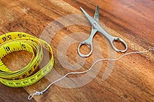 Sewing concept. Different sewing accessoires on a brown wooden background