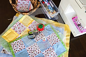 Sewing of handmade patchwork placemats with scissors, pool of threads and pin cushion