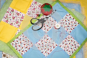 Sewing of handmade patchwork placemats with scissors, pool of threads and pin cushion