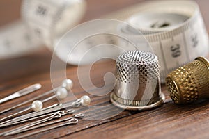 Sewing items - thimbles, including pins, measuring tape.