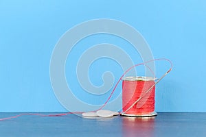 Sewing kit consisting of a cotton reel with red cotton a needle and three buttons