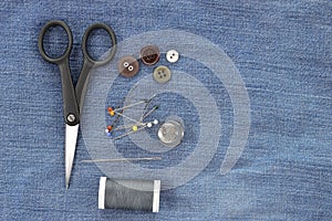 Sewing kit on jeans background, copy space.