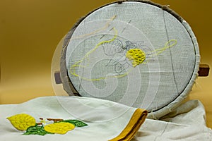 Sewing kit, needle, thread. On the frame is visible the canvas on which a lemon is being embroidered, at the end it will be like