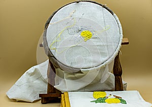 Sewing kit, needle, thread. On the frame is visible the canvas on which a lemon is being embroidered, at the end it will be like