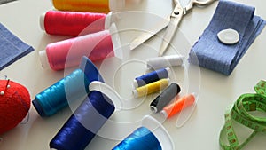 Sewing kit, sewing scissors, bobbins with thread, pincushion with needles, centimeter on a white table background