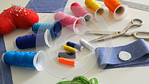 Sewing kit, sewing scissors, bobbins with thread, pincushion with needles, centimeter on a white table background