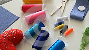 Sewing kit, sewing scissors, bobbins with thread, pincushion with needles, centimeter on a white table background
