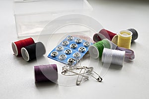 sewing kit thread needles pins and measuring tape on the table