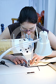 Chica de coser una tela sobre una máquina de coser.