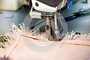 Sewing Machine Affixing Fringe to Pink Garment