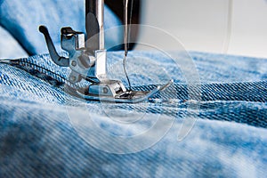 Sewing machine and blue jeans fabric. photo